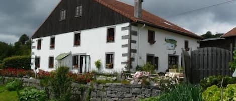 Vue sur la façade du gîte Les Tannes depuis le jardin