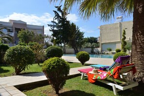 Relaxing sunbeds near swimming pool
