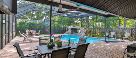 Screened-in, heated pool with outdoor dining and lounge area!