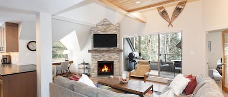 Living space with vaulted ceiling, fireplace, and TV