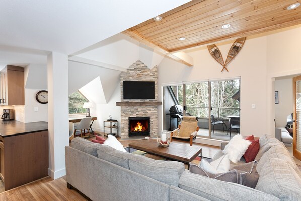 Living space with vaulted ceiling, fireplace, and TV