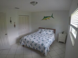 swordfish room with large closet and queen size bed with dresser and lamp