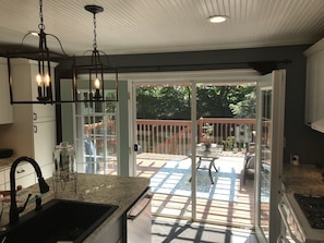 Double door wall that opens to deck with bbq grill and fountain