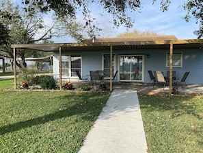 Covered patio under the oak trees provides a breezy and shady place to gather.