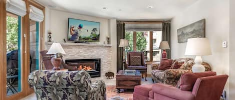 Comfortable living area with plenty of seating, bright natural light and electric fireplace.