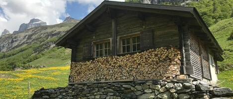 Alphütte Gental, mit  Holz für ein schönes Feuer im Ofen in der Stube