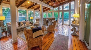 This spacious screened-in porch is perfect for family gatherings or enjoying some people-watching as they make their way to the beach.