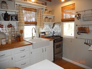 Adorable kitchen with fridge stove microwave dishes pots pans and extras