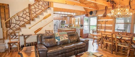 Great Room with Wood Floors, Exposed Beams, and Custom Branch Balustrade on Stairway to Upstairs Suite