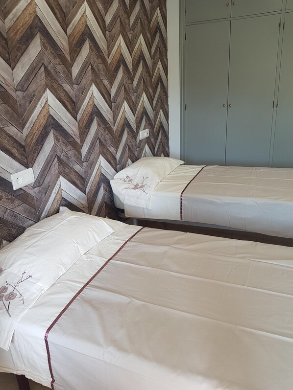 Dormitorio de dos camas individuales con  dos armarios