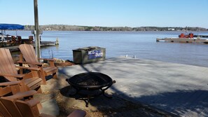 Flagstone sitting area with fire pit adjacent to dock.