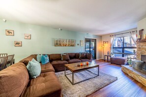 Bright living room w/ large windows and sliding glass door to sunroom.