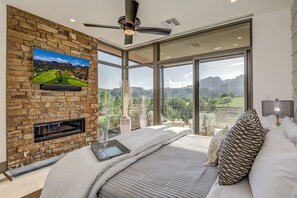 Master Bedroom with a King Bed, Stone Wall with a Gas Fireplace and 55" Smart TV, and Apple TV