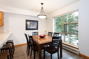 Dining area seats 8 comfortably with forested views