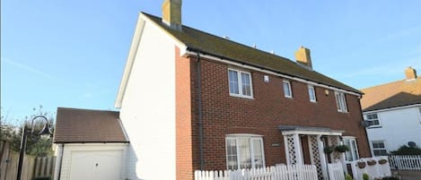 Front view with parking in front of house and garage