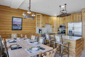 The kitchen and dining area with seating at the island for two and for six at the dining table.