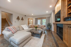 Living Room, large sectional with TV and surround sound stereo.