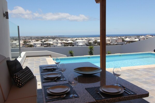 Barbecue Sitzplatz mit Blick über Pool und Meer