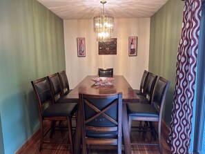 Dining room table with 8 or 10 chairs, plus an additional 4 stools for the peninsula snack bar.