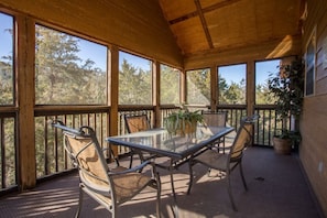 Screened porch with a dining set that can sit 4-6 people