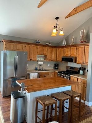 Fully stocked kitchen with gas range, dishwasher, and large fridge