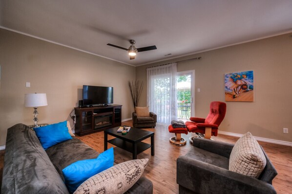 LIVING ROOM - 
This is a large gathering room with an Electric Fireplace, sofa bed and comfortable recliner chair. Large windows keep this room light and airy. The sliding door lead to the private balcony.