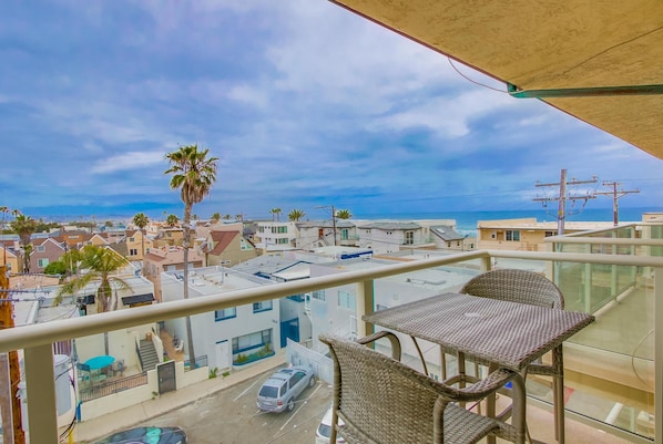 Balcony with an ocean view, seating for 2 and a grill.