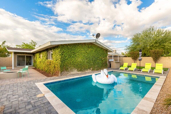 Your private backyard oasis with a heated pool, fire pit, and BBQ grill—ideal for sun or sunset relaxation.