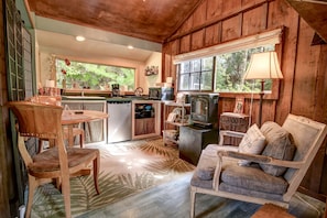Kitchenette with a small fridge, burners, microwave, toaster and dining area