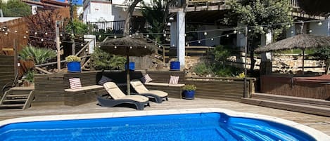Decked pool area with separate seating areas. 