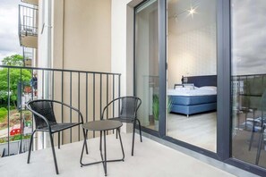 A private balcony with a small table and two chairs, perfect for enjoying a coffee or reading in the fresh air with a view of the surrounding area.