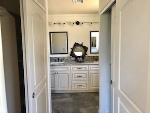 Hallway separating bedroom from his/her sink area.