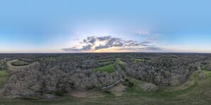 Drone view. Cabin is in the woods by the white truck.