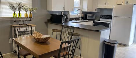 View of the eat in kitchen. We have four chairs around a table and two barstools. (photo updates 1/1/22)