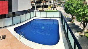 Piscina com espreguiçadeira.