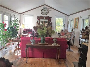 Charming, airy living room, 6 French doors (left) overlooking garden, fireplace