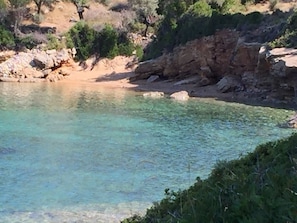 view of little sand beach below house