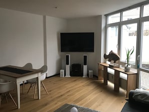 Living room with dining place and big flat TV with Hifi