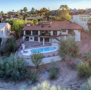 Putting green & hot tub added to the backyard, nestled next to desert terrain. 