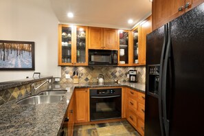 Gourmet kitchen features granite counters and contemporary appliances