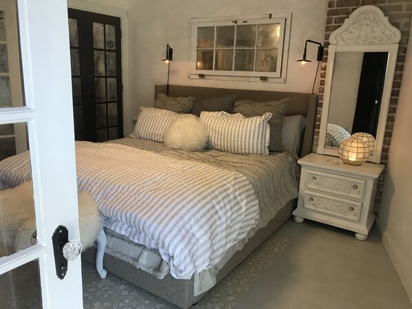 Sunroom looking though vintage french doors to a romantic large master bedroom. 