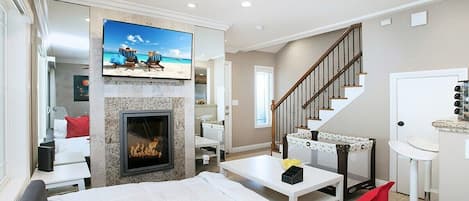 Sophisticated living room design with a sofa that opens up to full-size beds, 55” Smart TV, office/kitchen seating, beautiful decor, and much more.