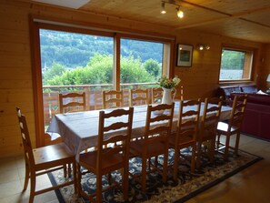 Dining area seating 12, sliding door to balcony.