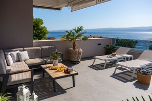 A terrace with lounge sitting, 6 deck chairs, and a private swimming pool