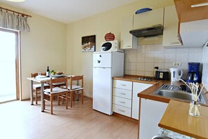 The living area with equipped kitchen, dining area with dining table and 4 chairs