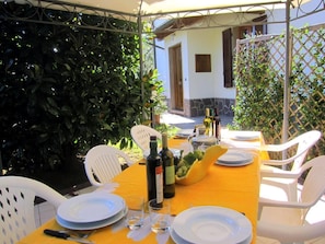 The pool terrace wiht gazebo, beach umbrella, deck chairs and loungers for sunbathing.