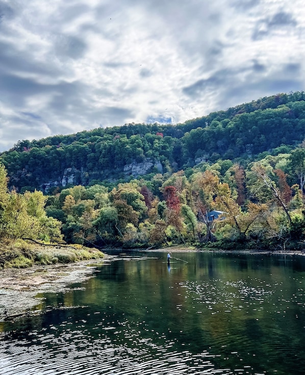 A beautiful fall day captures a fly fisherman in the shoals just below our dock.