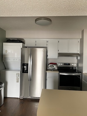 KITCHEN WITH BRAND NEW STAINLESS STEEL STOVE AND FRIDGE