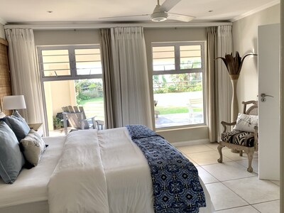 Bedroom looking out over green lawns and ocean views