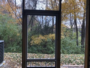 View from indoor patio overlooking the beautiful trees and a small lake 